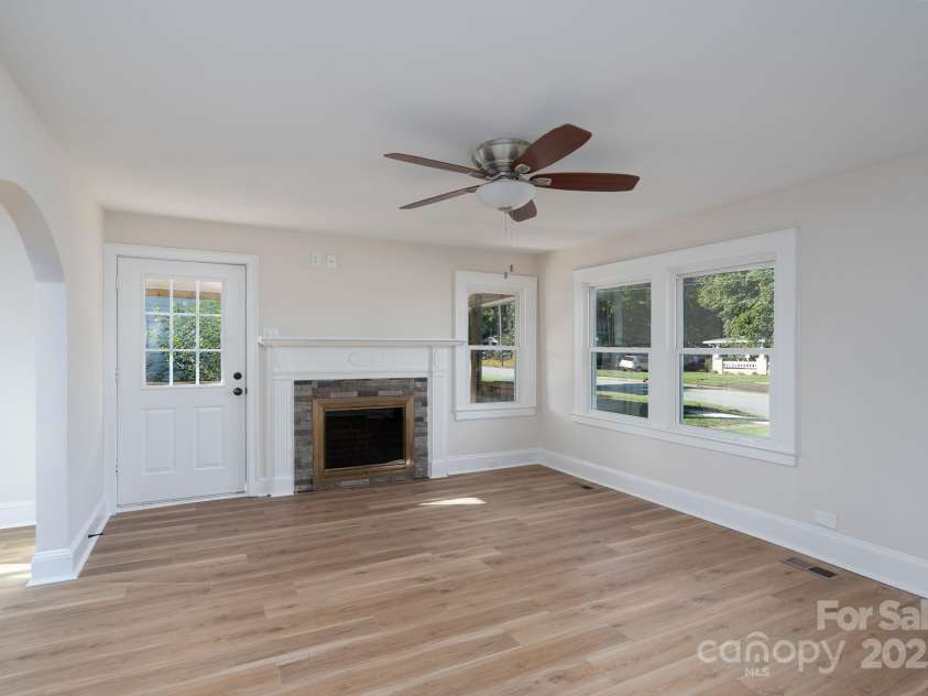 702 3rd Street, Spencer, NC 28159.  MLS# CAR4309115, YatesRealty ID 43594. Living room has a fireplace and nice mantle. New LVP flooring and fresh painting. Arched entry to the dining room to the left. 