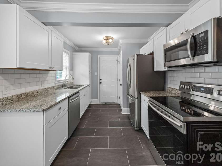 3137 Mathis Drive, Charlotte, NC 28208.  MLS# CAR4412024, YatesRealty ID 43639. Galley kitchen that leads out to the freshly painted back deck.