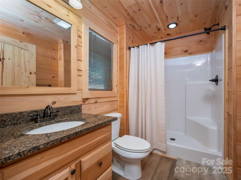 344 Wolf Trail, Lake Lure, NC 28746.  MLS# CAR4126442, YatesRealty ID 4372. Primary Full Bathroom with hickory cabinets and granite countertops.