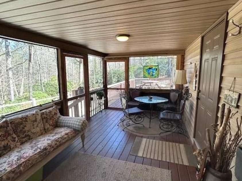 116 Minerva Lane, Sapphire, NC 28774.  MLS# CAR4237813, YatesRealty ID 4384. Screened porch looking out to open deck