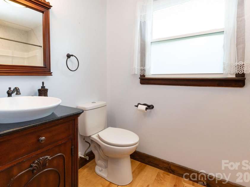 55 Banks Town Road, Weaverville, NC 28787.  MLS# CAR4395465, YatesRealty ID 43845. Convenient main-level second full bathroom with vanity and ample storage.