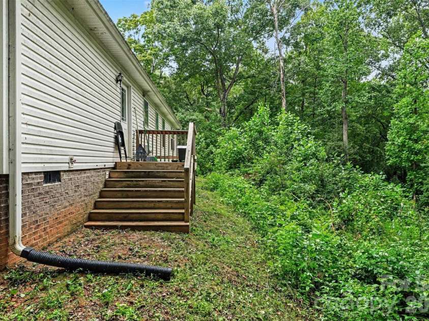 2998 Wilderness Trace, Claremont, NC 28610.  MLS# CAR4413940, YatesRealty ID 43985. Rear Deck & Wooded Yard