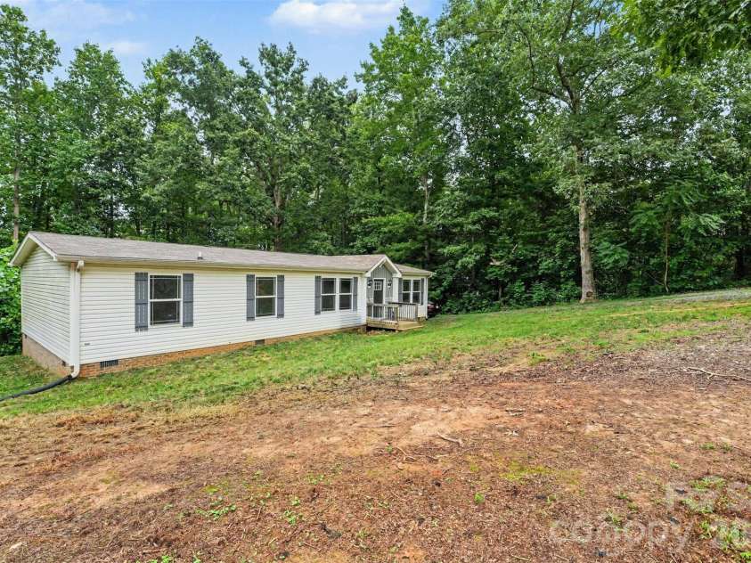 2998 Wilderness Trace, Claremont, NC 28610.  MLS# CAR4413940, YatesRealty ID 43985. Side Exterior & Acreage