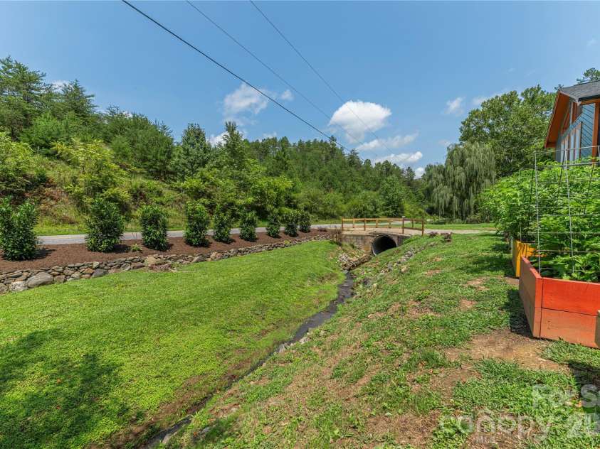 50 Embler Road, Alexander, NC 28701.  MLS# CAR4413083, YatesRealty ID 44048. Peaceful stream and full garden beds!