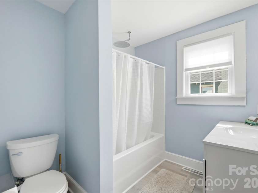 315 Pendleton Street, Rock Hill, SC 29730.  MLS# CAR4412482, YatesRealty ID 44209. A bathroom refresh done right. This bathroom features a new vanity and a rainshower head above the tub, with a calming color palette and natural light from the window.