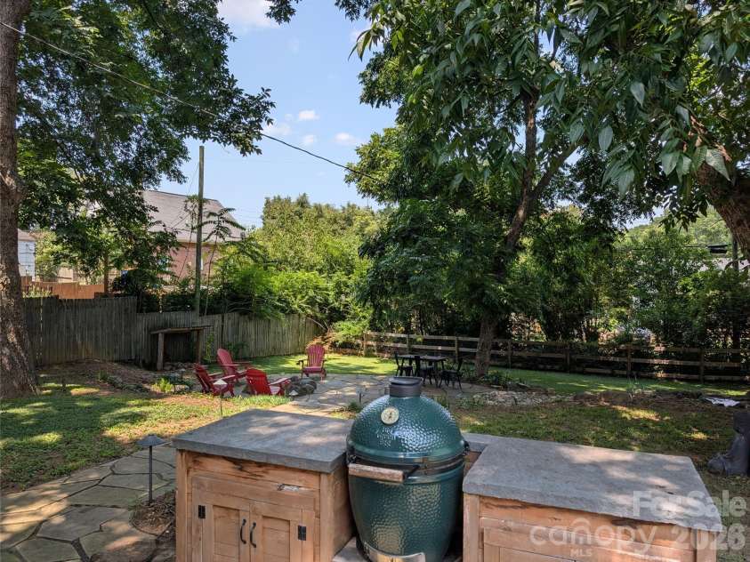 315 Pendleton Street, Rock Hill, SC 29730.  MLS# CAR4412482, YatesRealty ID 44209. The outdoor kitchen features a Big Green Egg, cedar storage cabinets, and a dedicated prep surface, all overlooking the backyard retreat below.