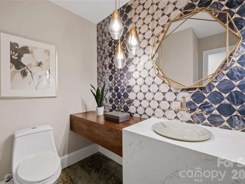5023 Gorham Drive, Charlotte, NC 28226.  MLS# CAR4402221, YatesRealty ID 44262. Designer powder room featuring a statement vanity, bold tilework and elevated lighting, adding an unexpected touch of luxury and personality.