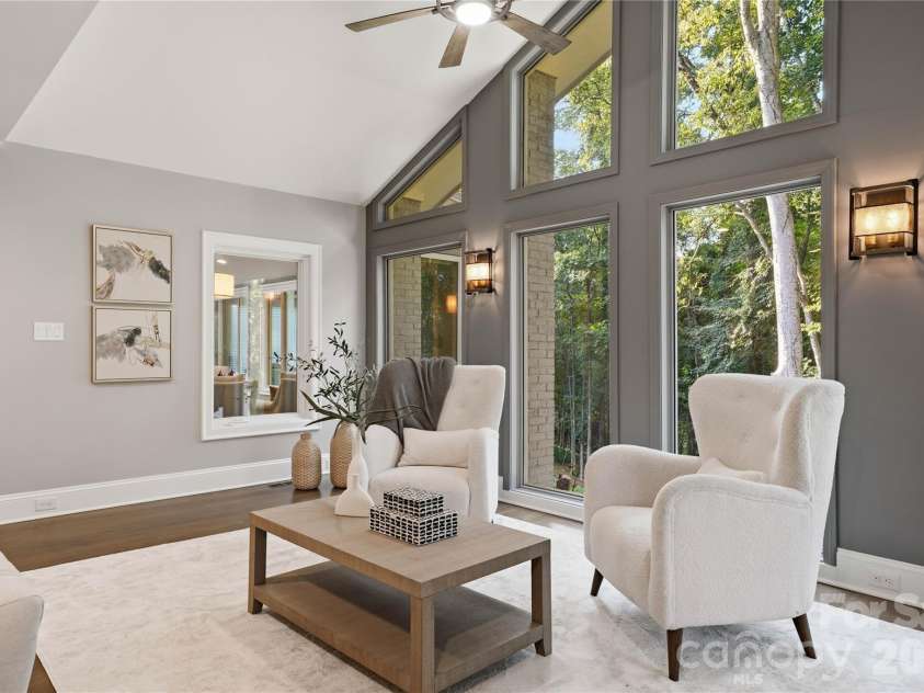 5023 Gorham Drive, Charlotte, NC 28226.  MLS# CAR4402221, YatesRealty ID 44262. Soaring ceilings and expansive architectural windows create a light filled retreat with picturesque treetop views, offering a peaceful connection to the home’s private natural setting.