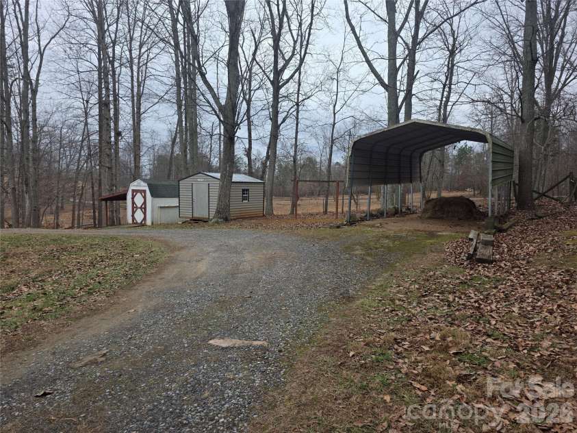 1044 Rabbit Trail, Gastonia, NC 28052.  MLS# CAR4334931, YatesRealty ID 4430. Wrap drive with carport, metal wired building and white/red building with lean to