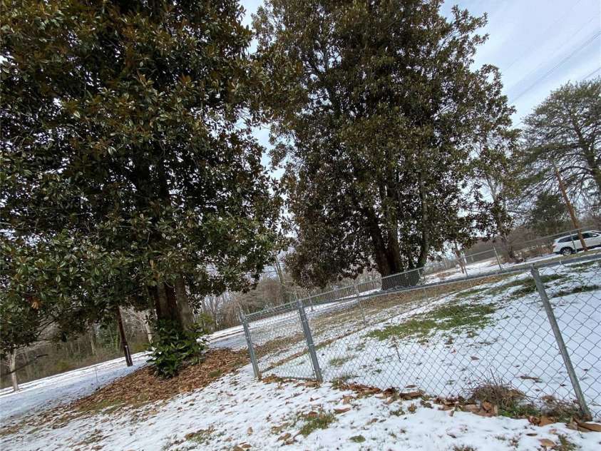 306 US Hwy 70A E Highway, Hildebran, NC 28637.  MLS# CAR4343164, YatesRealty ID 4431. LOOKING FROM SIDE OF HOUSE.  FRONT YARD FENCED SO KIDS AND PETS CAN BE SAFE.  GORGEOUS MAGNOLIA TREES
