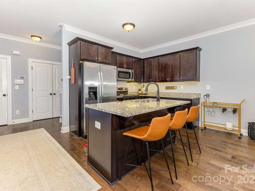 12304 Huntersville Concord Road, Huntersville, NC 28078.  MLS# CAR4268333, YatesRealty ID 4456. Open-Concept kitchen includes a kitchen island with sunken sink, disposal, and dishwasher. Nearby closet and double door pantry provide plenty of storage in a convenient location.
