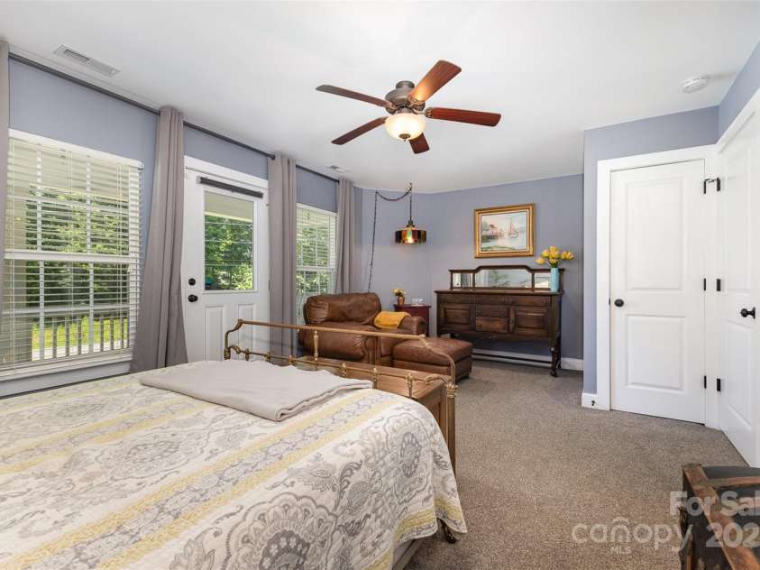 12304 Huntersville Concord Road, Huntersville, NC 28078.  MLS# CAR4268333, YatesRealty ID 4456. Primary bedroom with all of the amenities -  2 closets (1 walk-in closet, 1 traditional closet), ensuite full bath, access to covered balcony deck, sitting nook, and laundry just down the hall