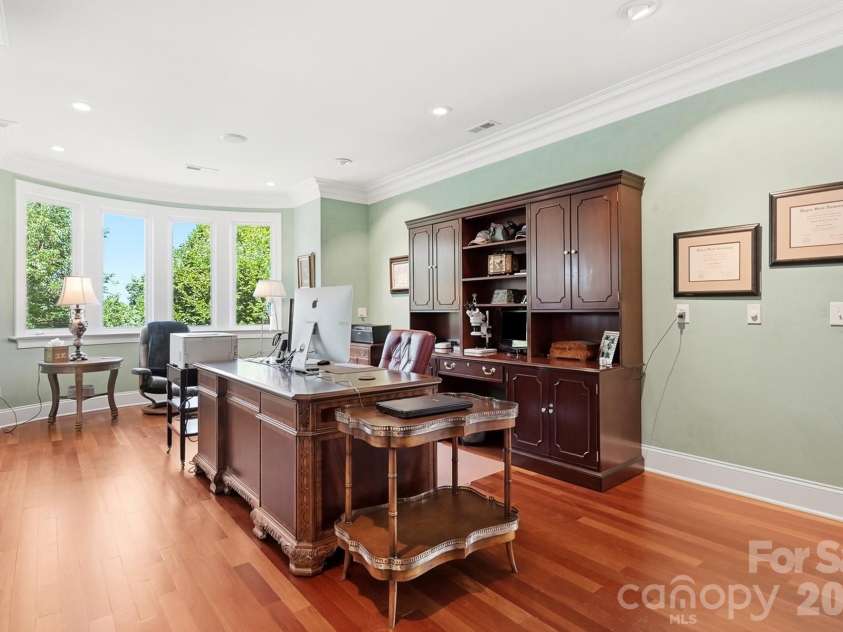 20124 Bascom Ridge Drive, Cornelius, NC 28031.  MLS# CAR4408389, YatesRealty ID 44623. A spacious private office offers an elegant work-from-home setting with hardwood floors, extensive built-in cabinetry, recessed lighting, and a large walk-in storage closet conveniently located just behind the off