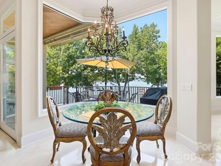 20124 Bascom Ridge Drive, Cornelius, NC 28031.  MLS# CAR4408389, YatesRealty ID 44623. Just beyond the kitchen, the bright breakfast area offers a relaxed place to dine while enjoying expansive views toward Lake Norman through oversized windows. The open archway connects seamlessly to the two-story 