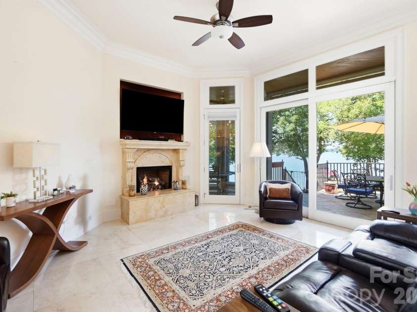 20124 Bascom Ridge Drive, Cornelius, NC 28031.  MLS# CAR4408389, YatesRealty ID 44623. Snug between the kitchen and breakfast area, this comfortable sitting room offers a more intimate place to relax, complete with a fireplace and direct access to the lakeside terrace.