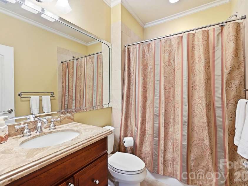 20124 Bascom Ridge Drive, Cornelius, NC 28031.  MLS# CAR4408389, YatesRealty ID 44623. The adjoining bath features a stone-topped vanity, large mirror, tub/shower combination, and classic finishes, giving overnight guests or family members a convenient and comfortable stay.