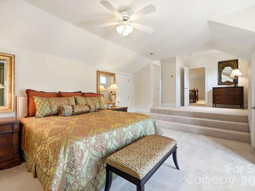 20124 Bascom Ridge Drive, Cornelius, NC 28031.  MLS# CAR4408389, YatesRealty ID 44623. This spacious upper-level bedroom offers a private retreat with a vaulted ceiling, generous floor space, soft carpeting, and convenient access to the adjoining full bath. Its flexible layout provides plenty of roo
