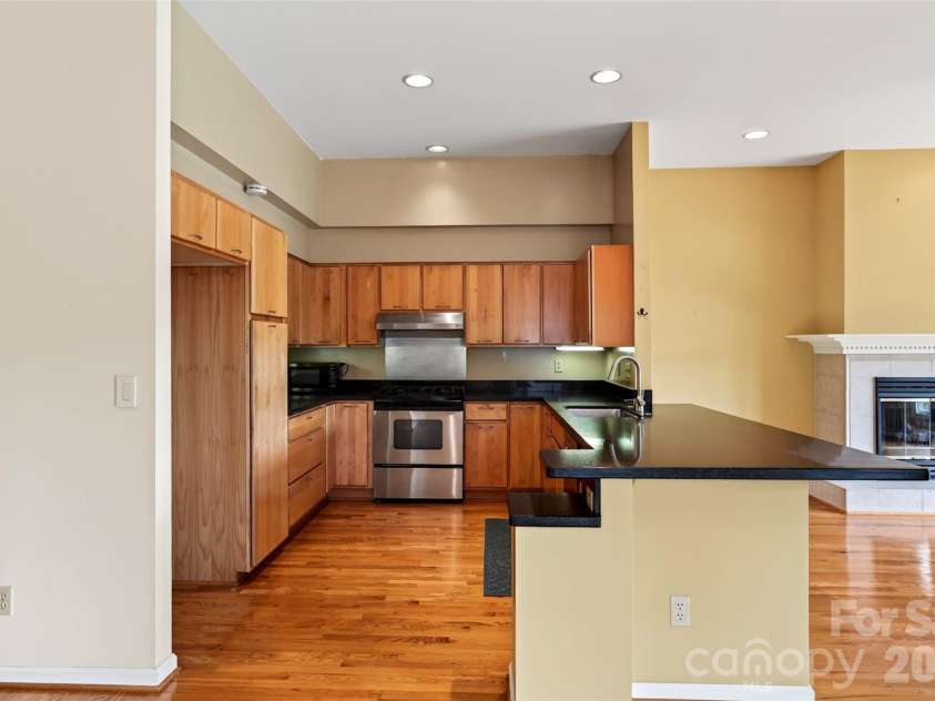 16 Spring Hollow Circle, Asheville, NC 28805.  MLS# CAR4412401, YatesRealty ID 44657. Open kitchen with quartz countertops, maple cabinets, and counter seating.