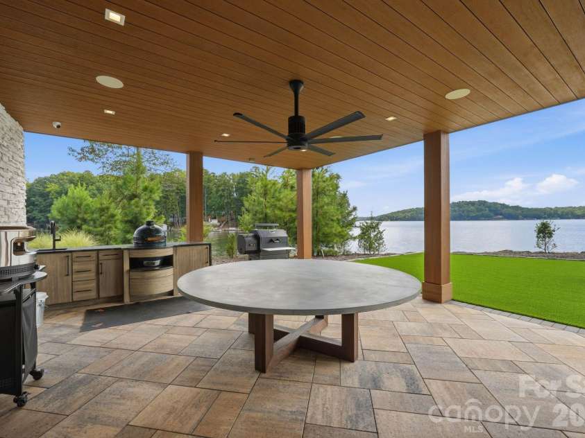 123 Cove Point, Mount Gilead, NC 27306.  MLS# CAR4408189, YatesRealty ID 44817. Outdoor kitchen featuring a pizza oven, Big Green Egg, Yoder smoker, and zinc-top table (lower level patio)