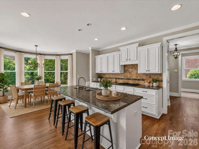 447 Three Greens Drive, Huntersville, NC 28078.  MLS# CAR4414048, YatesRealty ID 44824. Concept Photo (virtually staged) - Spacious kitchen features abundant white cabinetry, granite countertops, a large center island with seating, and an adjoining light-filled breakfast area.