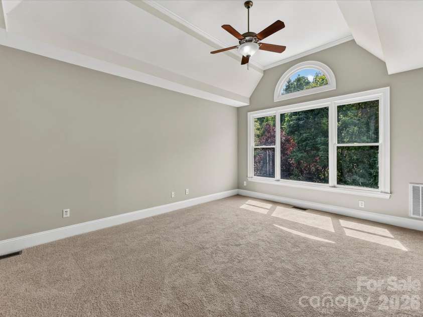 447 Three Greens Drive, Huntersville, NC 28078.  MLS# CAR4414048, YatesRealty ID 44824. Non staged - Spacious primary suite features a tray ceiling, oversized windows, abundant natural light, and a private ensuite bath.