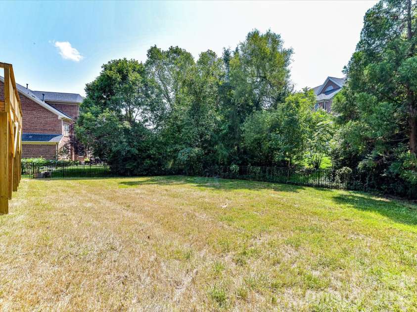447 Three Greens Drive, Huntersville, NC 28078.  MLS# CAR4414048, YatesRealty ID 44824. Spacious backyard offers a level lawn framed by mature trees, creating a private setting for outdoor enjoyment.