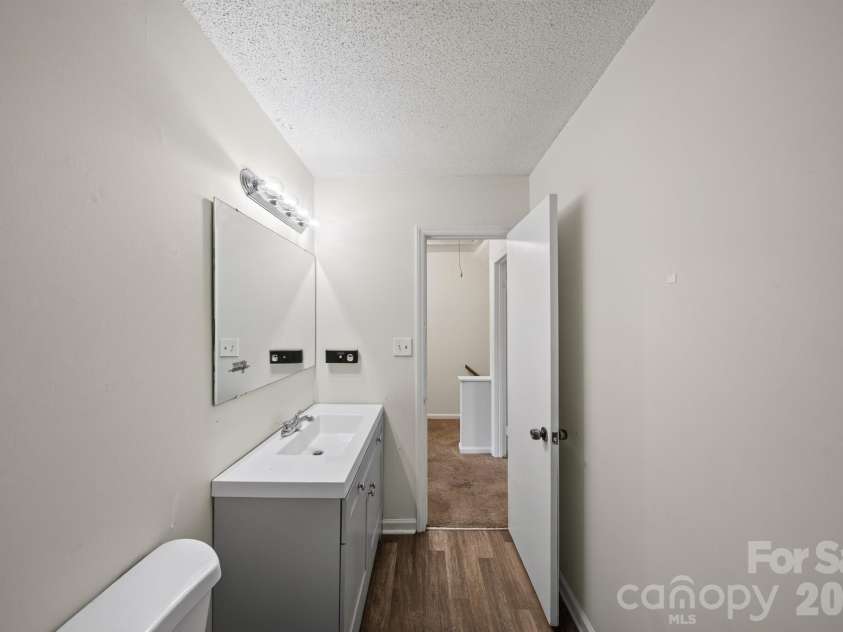 6835 Farmingdale Drive, Charlotte, NC 28212.  MLS# CAR4412722, YatesRealty ID 44983. Primary bathroom featuring a spacious vanity, large mirror, ample lighting, and durable flooring with a clean, neutral finish.