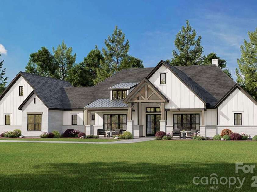 Lot 4 Country Estates Drive, Waxhaw, NC 28173.  MLS# CAR4278303, YatesRealty ID 4510. Large windows and clean lines offer a perfect blend of classic charm and contemporary design, all set against a lush green lawn and mature trees for a picturesque country feel.