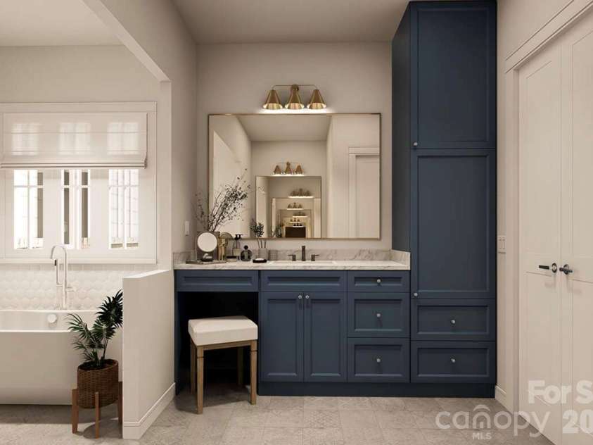 Lot 4 Country Estates Drive, Waxhaw, NC 28173.  MLS# CAR4278303, YatesRealty ID 4510. Navy blue cabinetry with marble countertops and brass fixtures adds a bold yet elegant touch, complemented by a dedicated vanity area and built-in storage tower for optimal functionality.