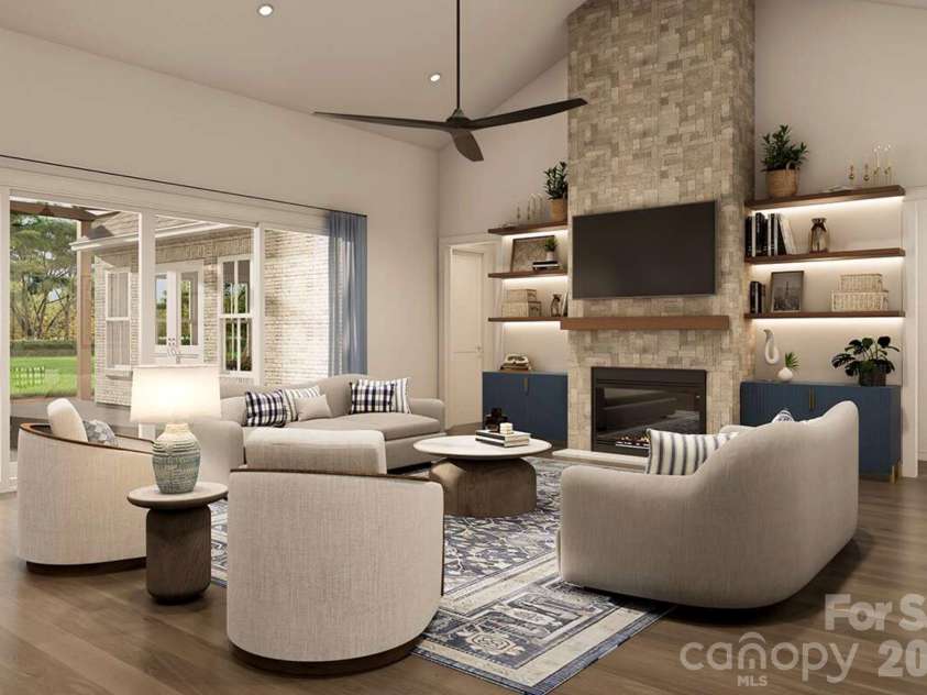 Lot 4 Country Estates Drive, Waxhaw, NC 28173.  MLS# CAR4278303, YatesRealty ID 4510. This inviting living room blends modern comfort with timeless elegance. A floor-to-ceiling stone fireplace anchors the space, flanked by built-in shelves with accent lighting and navy cabinetry for a pop of color.