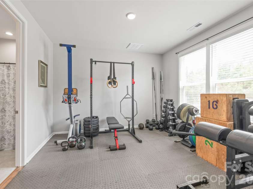 6440 Ancient Way, Fort Mill, SC 29707.  MLS# CAR4413430, YatesRealty ID 45254. Conveniently located on the main level, this spacious guest bedroom offers complete privacy and access to its own private full bathroom, making it ideal for visitors, multi-generational living, or even a home gym.