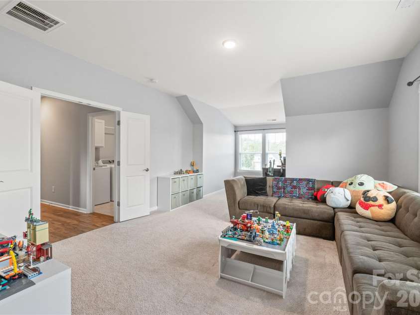 6440 Ancient Way, Fort Mill, SC 29707.  MLS# CAR4413430, YatesRealty ID 45254. Framed by double doors, this spacious bonus room offers a versatile space perfect for a home theater, play area, or lounge.