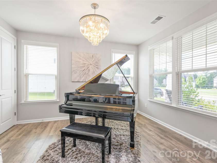 6440 Ancient Way, Fort Mill, SC 29707.  MLS# CAR4413430, YatesRealty ID 45254. Located right off the entry, this versatile office or flex space is bathed in natural light, featuring rich LVP floors and a statement designer chandelier.