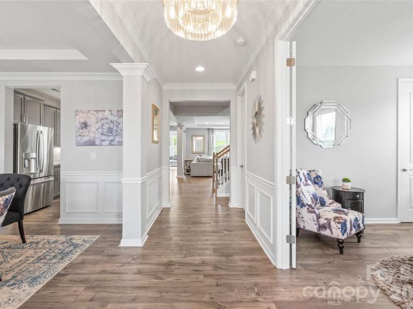 6440 Ancient Way, Fort Mill, SC 29707.  MLS# CAR4413430, YatesRealty ID 45254. Step into a light-filled entry featuring cohesive LVP flooring, elegant custom trimwork, and updated designer lighting that immediately sets a sophisticated, modern tone.
