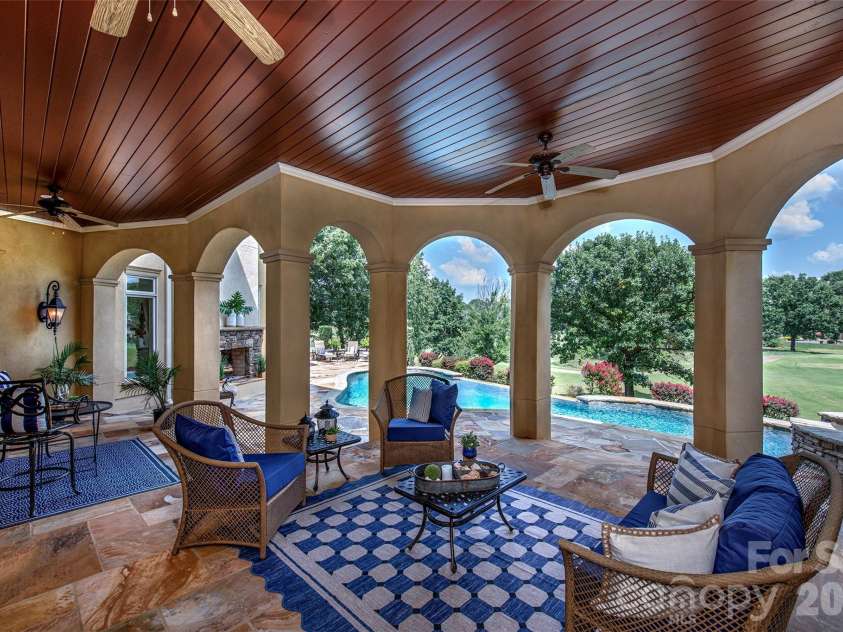 14905 Mcleary Circle, Charlotte, NC 28277.  MLS# CAR4410843, YatesRealty ID 45266. Expansive covered lower-level porch overlooking the stunning infinity-edge pool, offering plenty of space for comfortable seating, relaxing, and entertaining.