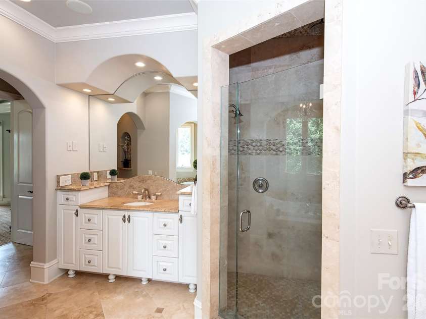 14905 Mcleary Circle, Charlotte, NC 28277.  MLS# CAR4410843, YatesRealty ID 45266. The luxurious primary shower is designed for a true spa-like experience, featuring dual shower heads, an overhead rain shower, and elegant seamless glass doors that enhance both the beauty and functionality of the spa