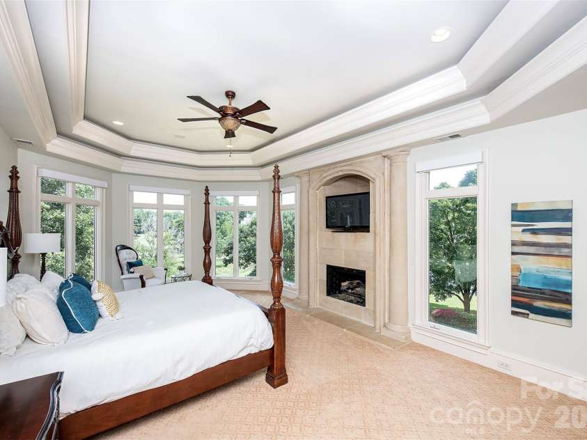 14905 Mcleary Circle, Charlotte, NC 28277.  MLS# CAR4410843, YatesRealty ID 45266. The luxurious primary suite is a private retreat featuring an elegant double tray ceiling with recessed lighting, dedicated HVAC system specific for this room, ceiling fan, and a stunning gas fireplace with a beautifu