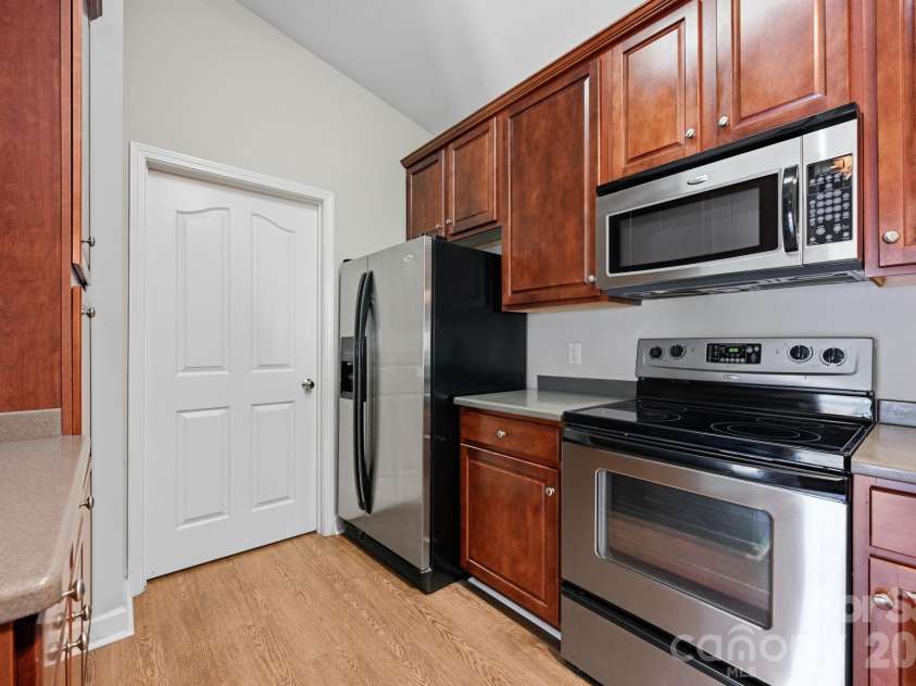 16648 Amberside Road, Cornelius, NC 28031.  MLS# CAR4414323, YatesRealty ID 45276. More cabinets and large side by side refrigerator. Door opens to laundry room and storage.
