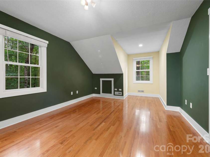 236 Holland Drive, Black Mountain, NC 28711.  MLS# CAR4412802, YatesRealty ID 45307. Spacious upstairs bedroom featuring charming dormer windows—a perfect, inviting space to call home.