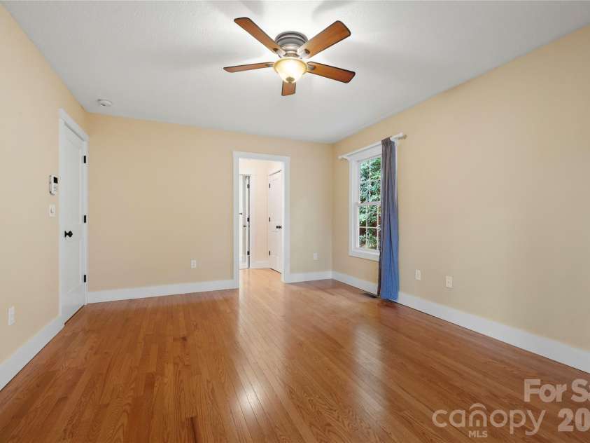 236 Holland Drive, Black Mountain, NC 28711.  MLS# CAR4412802, YatesRealty ID 45307. The main-level primary suite features a spacious ensuite bath and private access to a beautiful heated and cooled sunroom, creating a peaceful retreat to enjoy year-round.