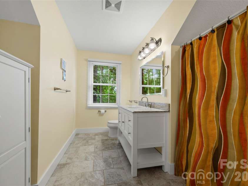 236 Holland Drive, Black Mountain, NC 28711.  MLS# CAR4412802, YatesRealty ID 45307. This thoughtfully updated second-floor bathroom is situated between the two upstairs bedrooms, offering a spacious layout with ample storage.
