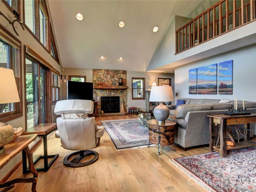 509 Deer Creek Trail, Maggie Valley, NC 28751.  MLS# CAR4408706, YatesRealty ID 45359. Great room with rock facade propane log fireplace