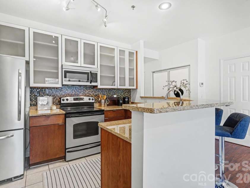 525 Graham Street, Charlotte, NC 28202.  MLS# CAR4341824, YatesRealty ID 4546. Functional breakfast bar with two stools — ideal for casual meals, work-from-home, or guests