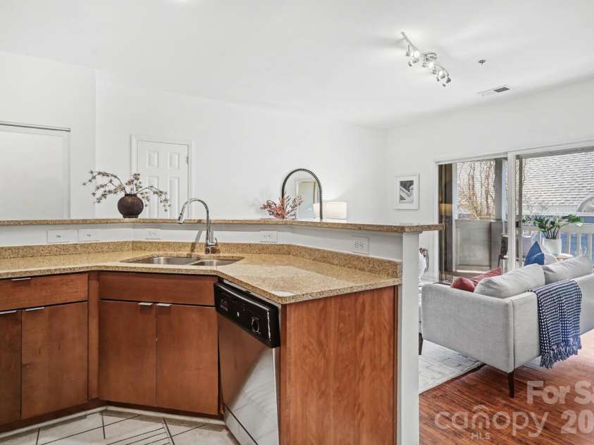 525 Graham Street, Charlotte, NC 28202.  MLS# CAR4341824, YatesRealty ID 4546. Well-designed kitchen with wraparound granite counters and stainless appliances — efficient yet functional