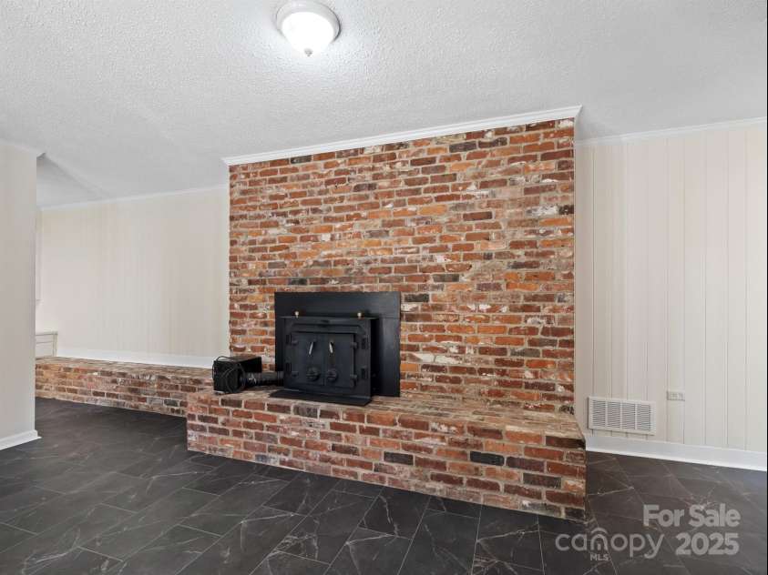2111 Sagamore Road, Charlotte, NC 28209.  MLS# CAR4323130, YatesRealty ID 455. Lower level family room with fireplace