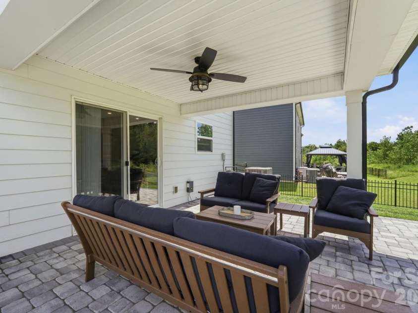 4492 Falls Lake Drive, Concord, NC 28025.  MLS# CAR4413181, YatesRealty ID 45507. Covered stone patio with ceiling fan.