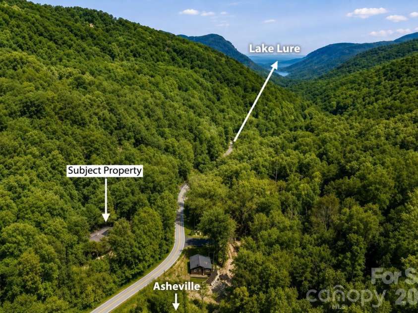 2752 Gerton Highway, Gerton, NC 28735.  MLS# CAR4409357, YatesRealty ID 45515. Aerial perspective highlighting the home's private mountain setting, with directionals indicating the routes toward Lake Lure and Asheville