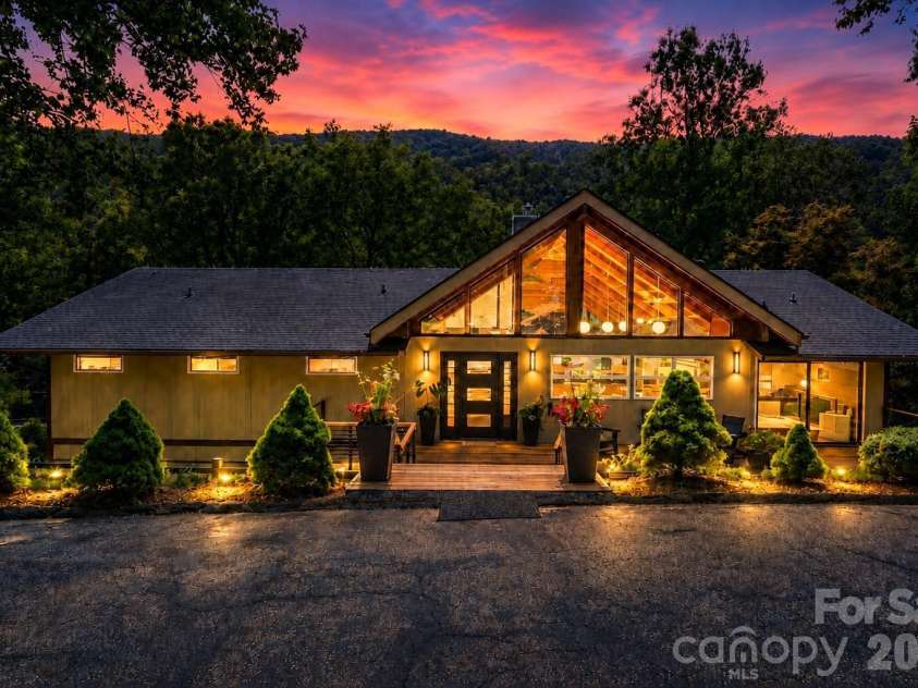 2752 Gerton Highway, Gerton, NC 28735.  MLS# CAR4409357, YatesRealty ID 45515. Virtually enhanced twilight view showcasing the home’s dramatic architecture and beautiful mountain setting