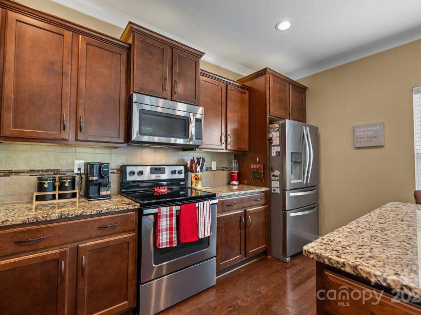 12545 Druids Glen Drive, Pineville, NC 28134.  MLS# CAR4234518, YatesRealty ID 4552. Kitchen with granite counters and stainless steel appliances