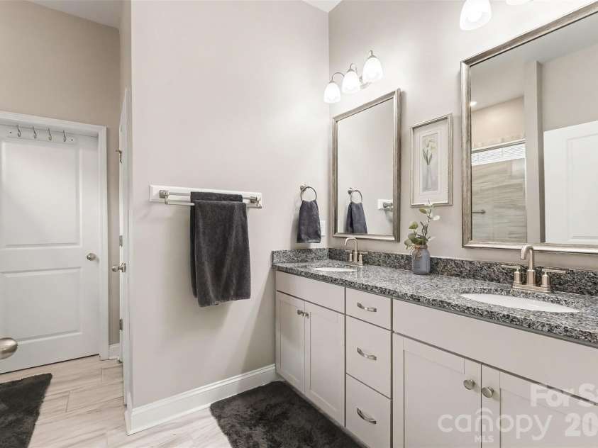 676 Latrobe Drive, Iron Station, NC 28080.  MLS# CAR4401657, YatesRealty ID 45521. Beautiful primary bath featuring dual sinks with granite countertops, offering style and functionality